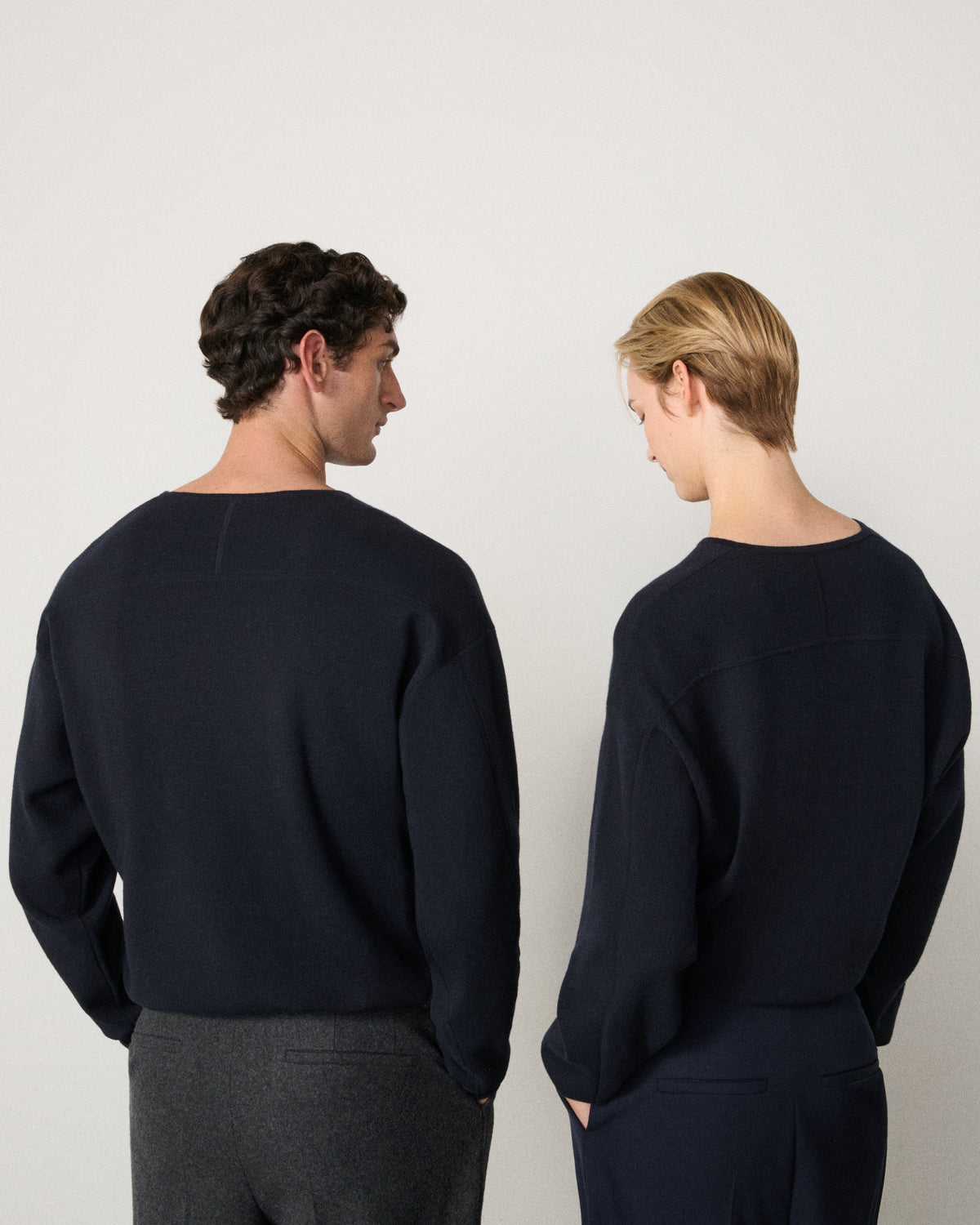 man and woman wearing the indigo sweatshirt, back view