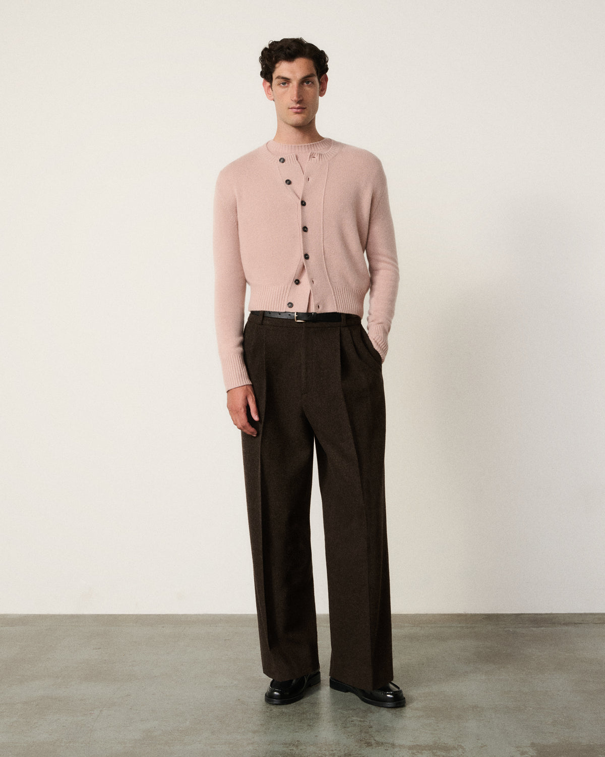 man in the blush pink cropped cardigan, dark brown trousers