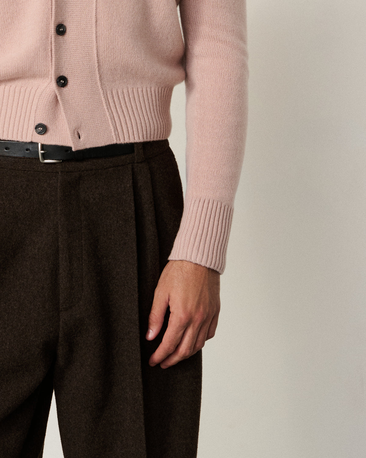 close-up of a man's hand and the blush pink cardigan cuff