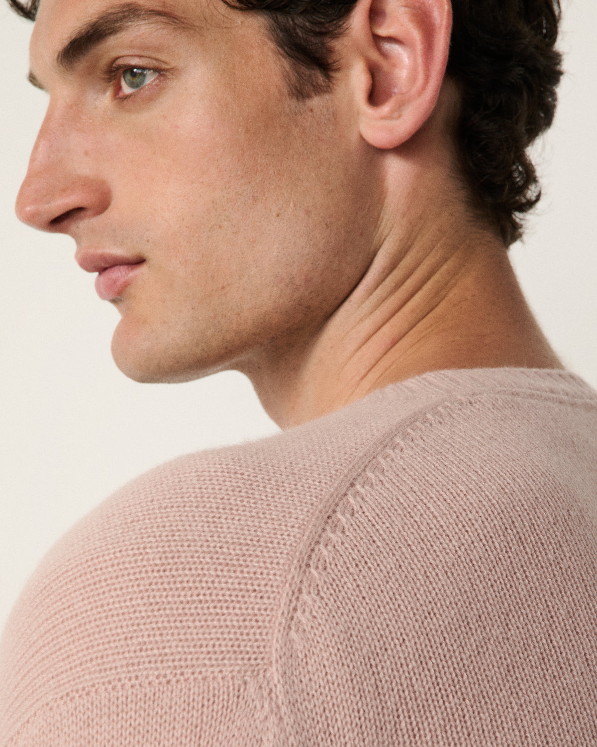 close-up of a man's face and neck in the blush pink cardigan