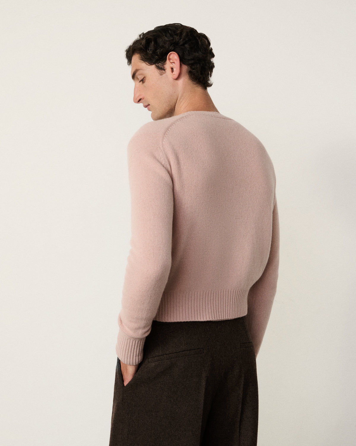 man in the blush pink cropped cardigan, back view