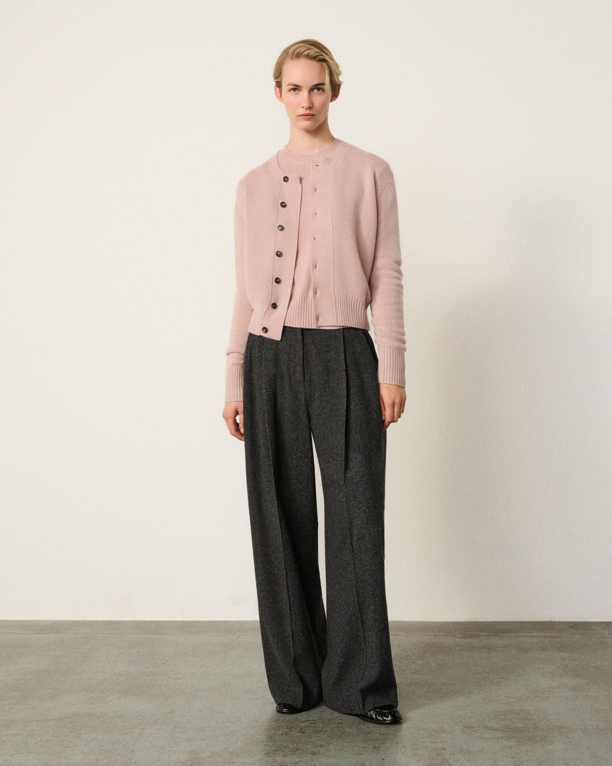 woman in the blush pink cropped cardigan, grey trousers