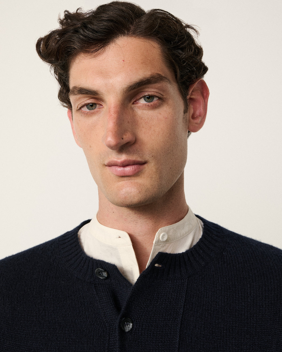 close-up of a man wearing the navy cropped cardigan