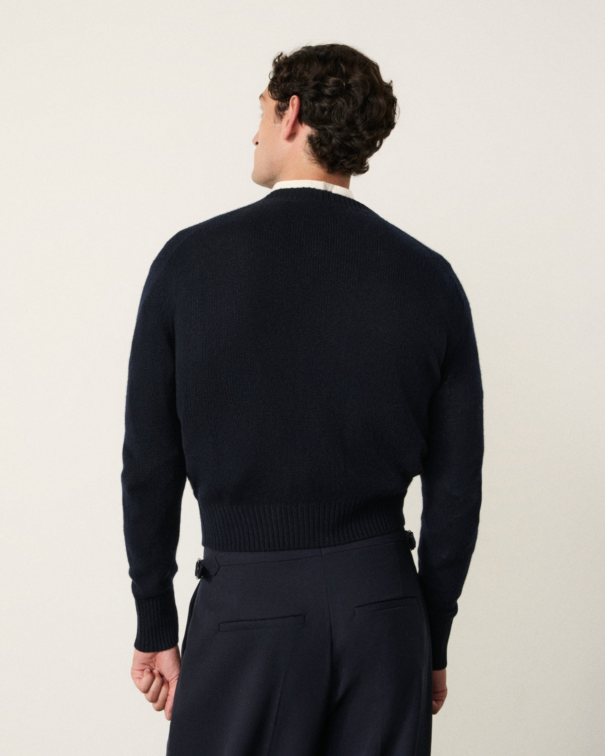 man in the navy cropped cardigan, back view