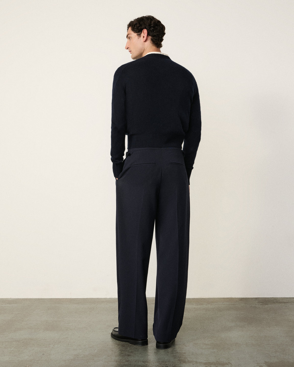 man in the navy cropped cardigan, back view