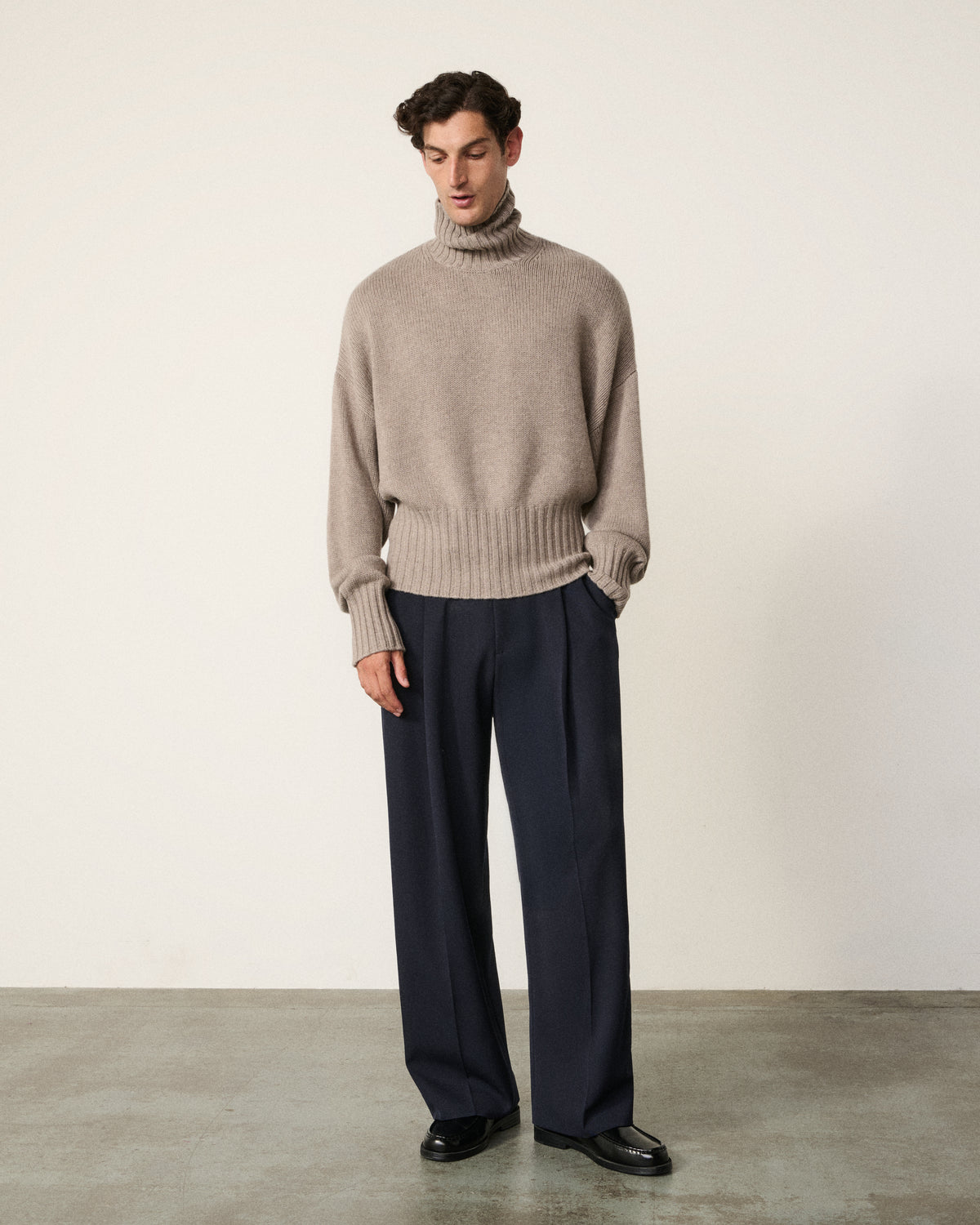 man in the mink turtle neck sweater, looking down