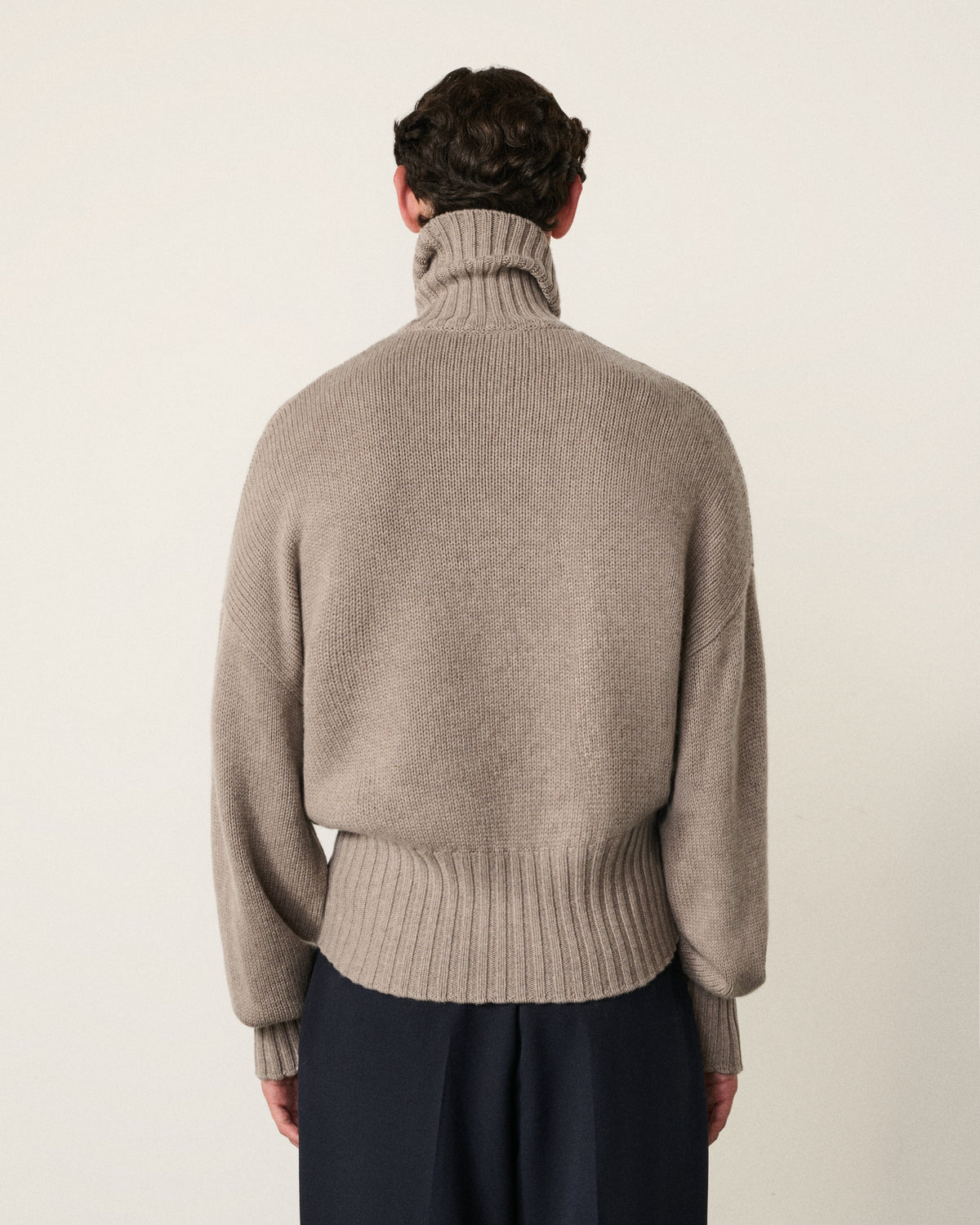 man in the mink turtle neck sweater, back view