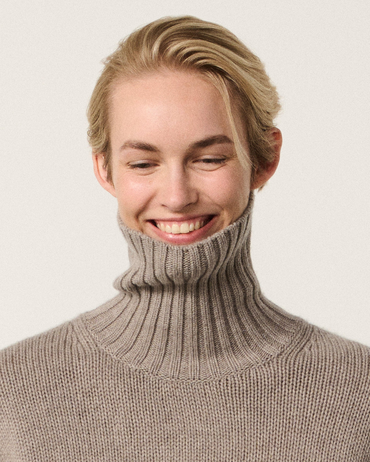 woman smiling in the mink turtle neck sweater