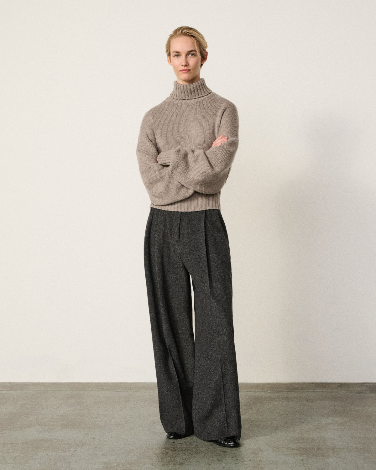 woman wearing the mink turtle neck sweater, arms crossed