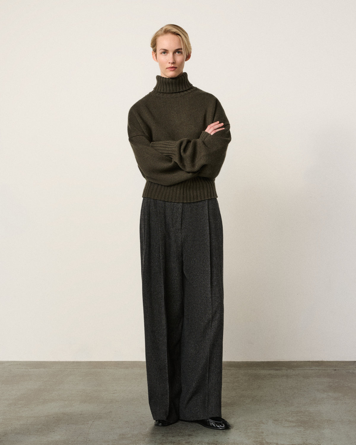 woman in the olive relaxed turtle neck sweater, arms crossed