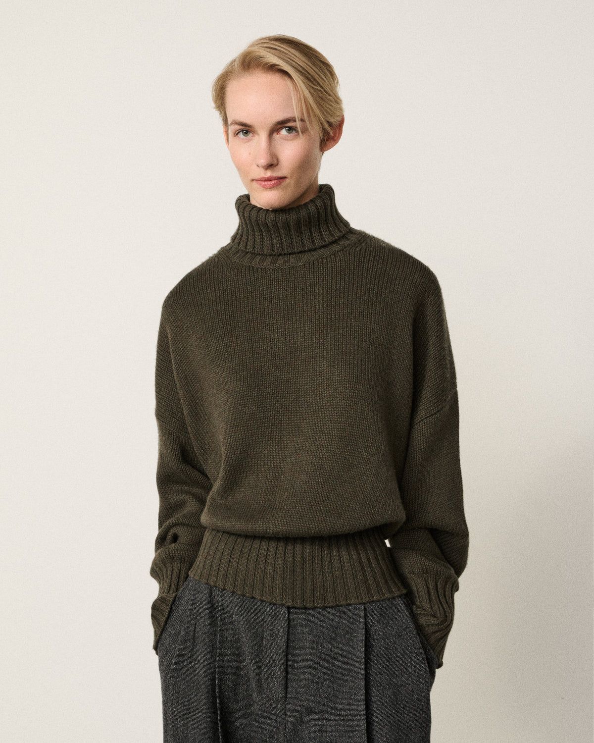 woman in the olive relaxed turtle neck sweater, front view