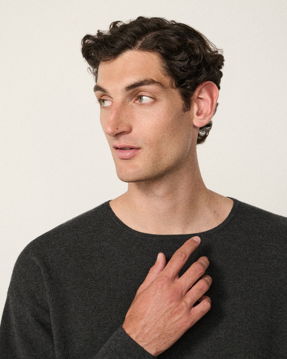 close-up of man's face, hand at chest