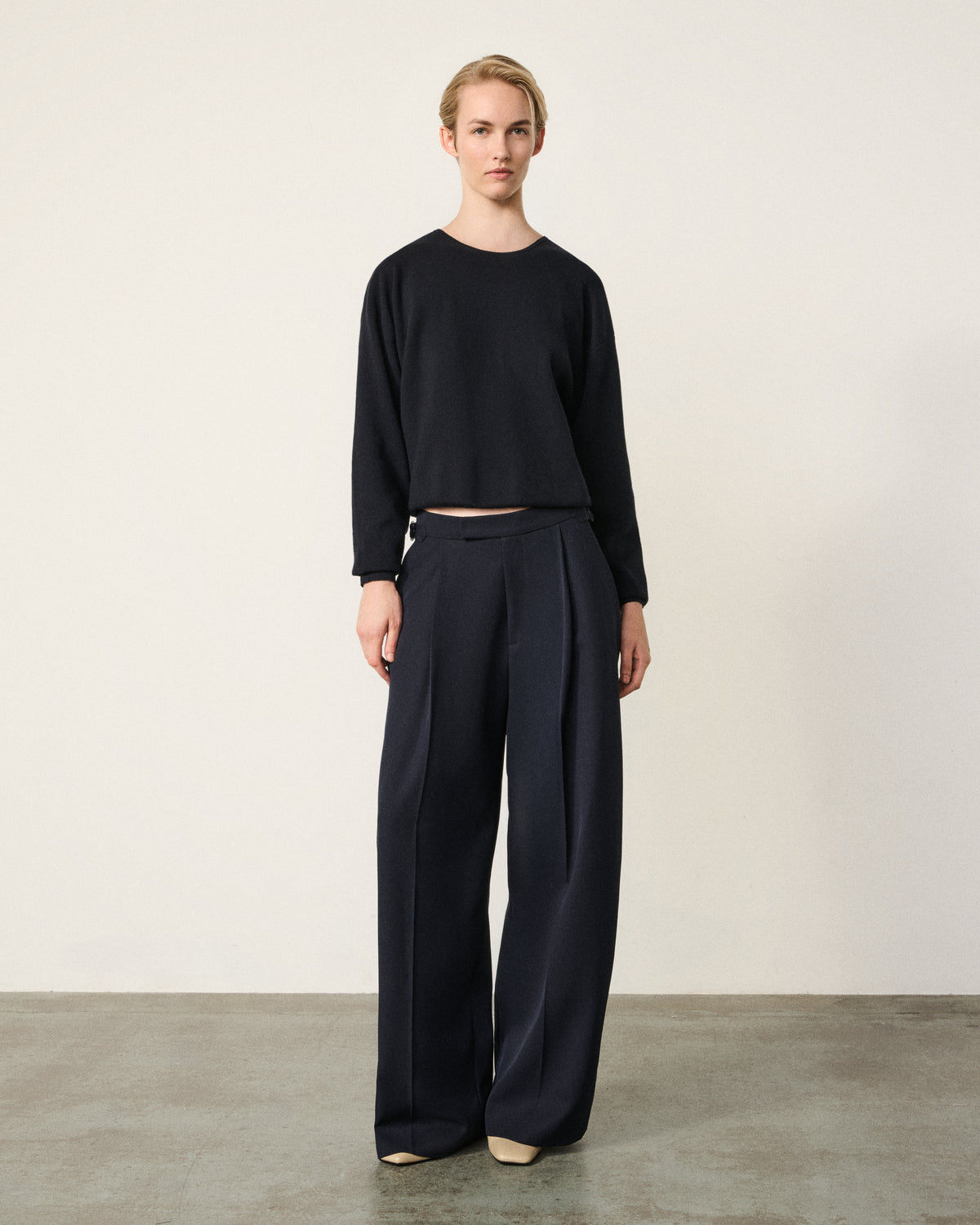 woman in the navy everyday tailored pant, black cropped top, front view
