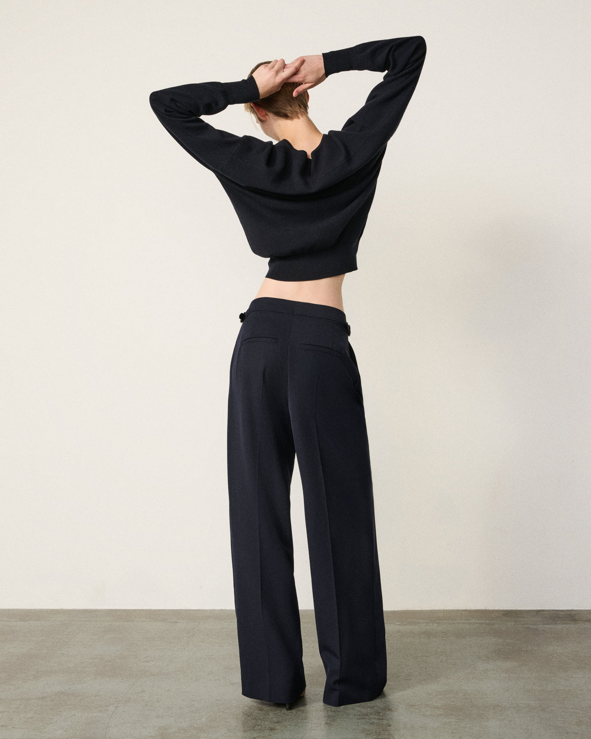 close-up of a man's torso in the navy tailored pant and grey henley