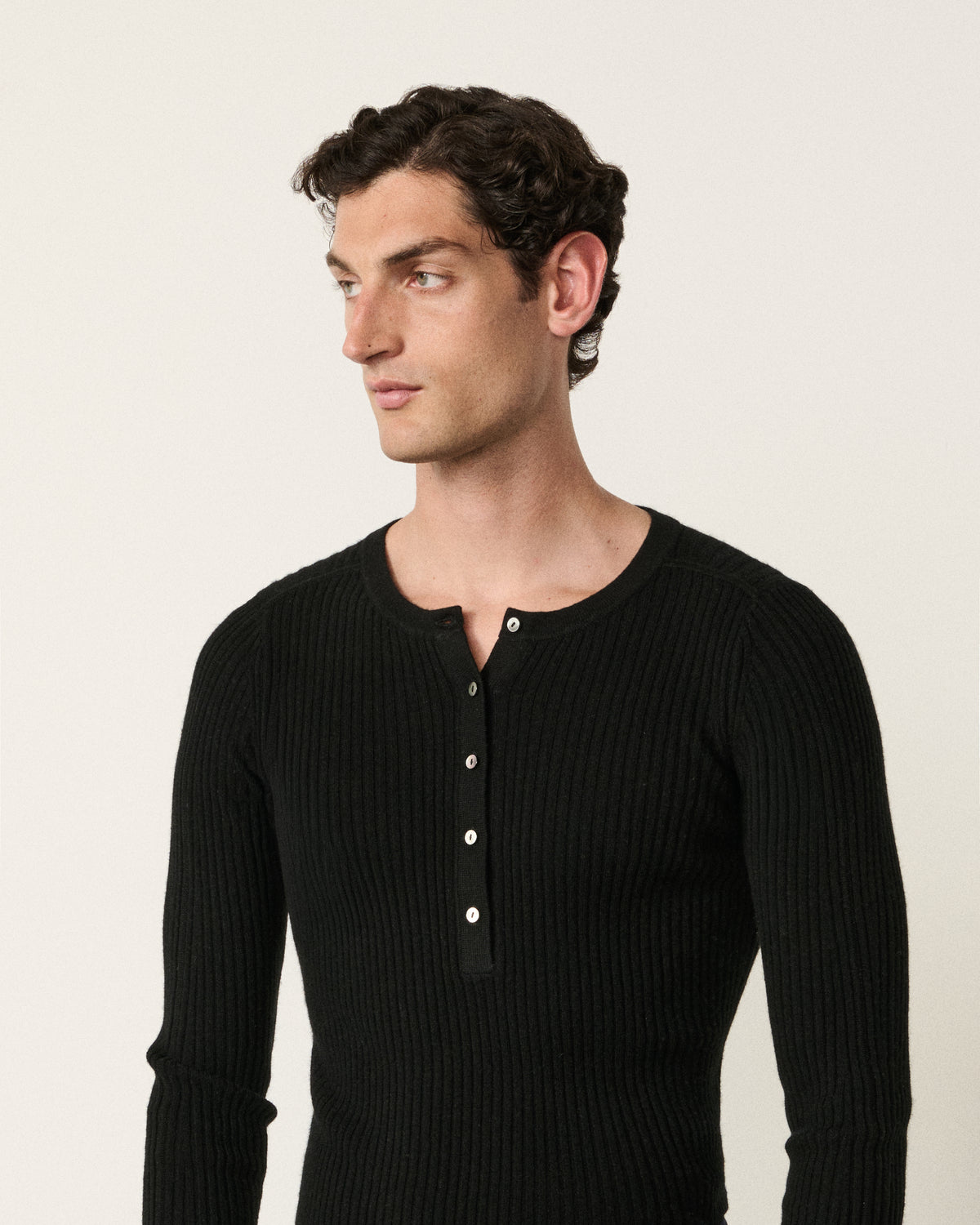 close-up of a man wearing the black henley top