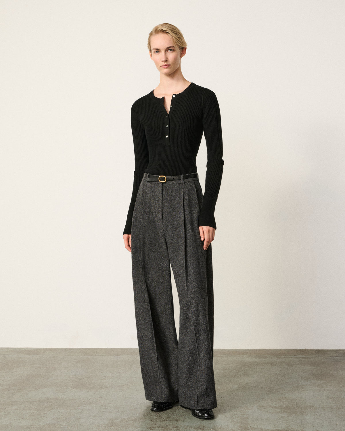 woman wearing the black ribbed knitted henley top