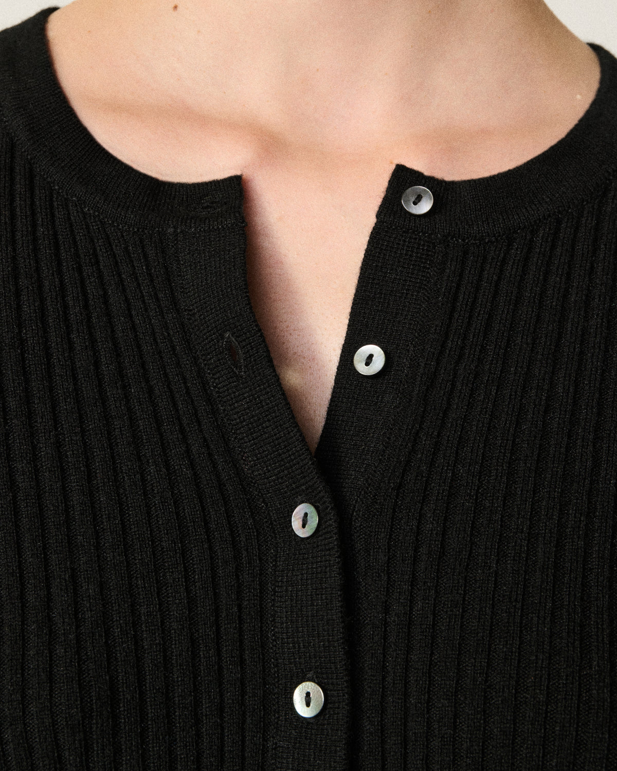 close-up of a woman's neckline on the black henley top