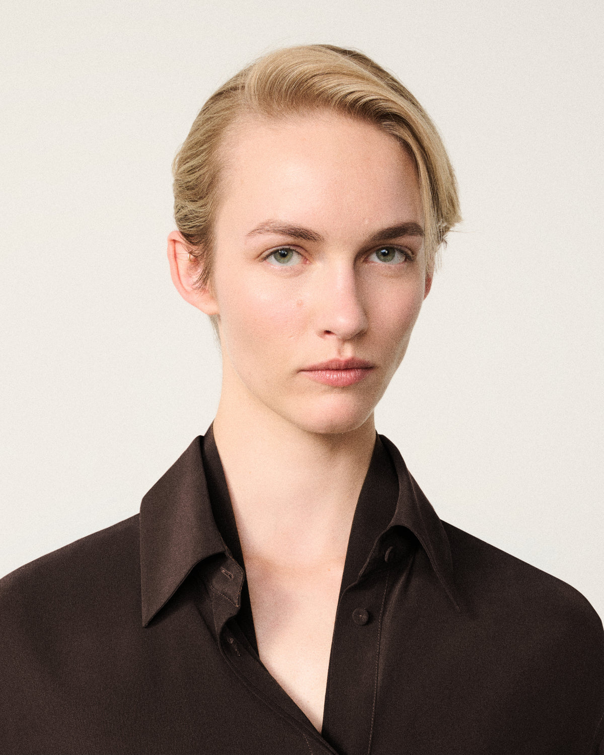 close-up of woman's face, chocolate silk shirt