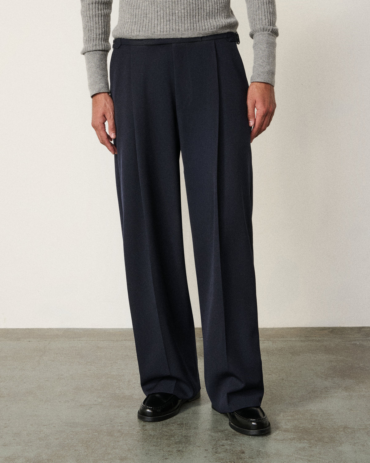 man in the navy everyday tailored pant, grey sweater, hand in pocket
