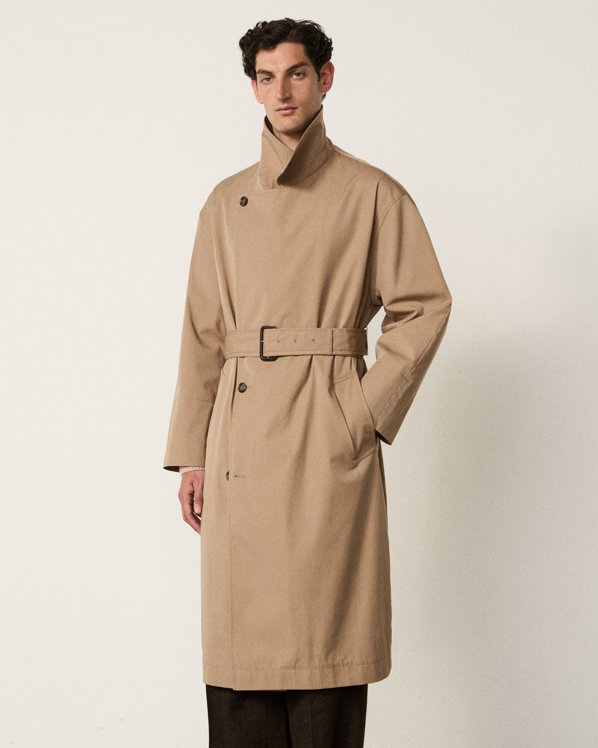 man in the sand belted trench coat