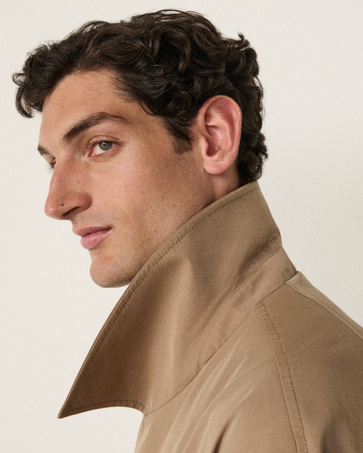 man in the sand trench coat, side profile