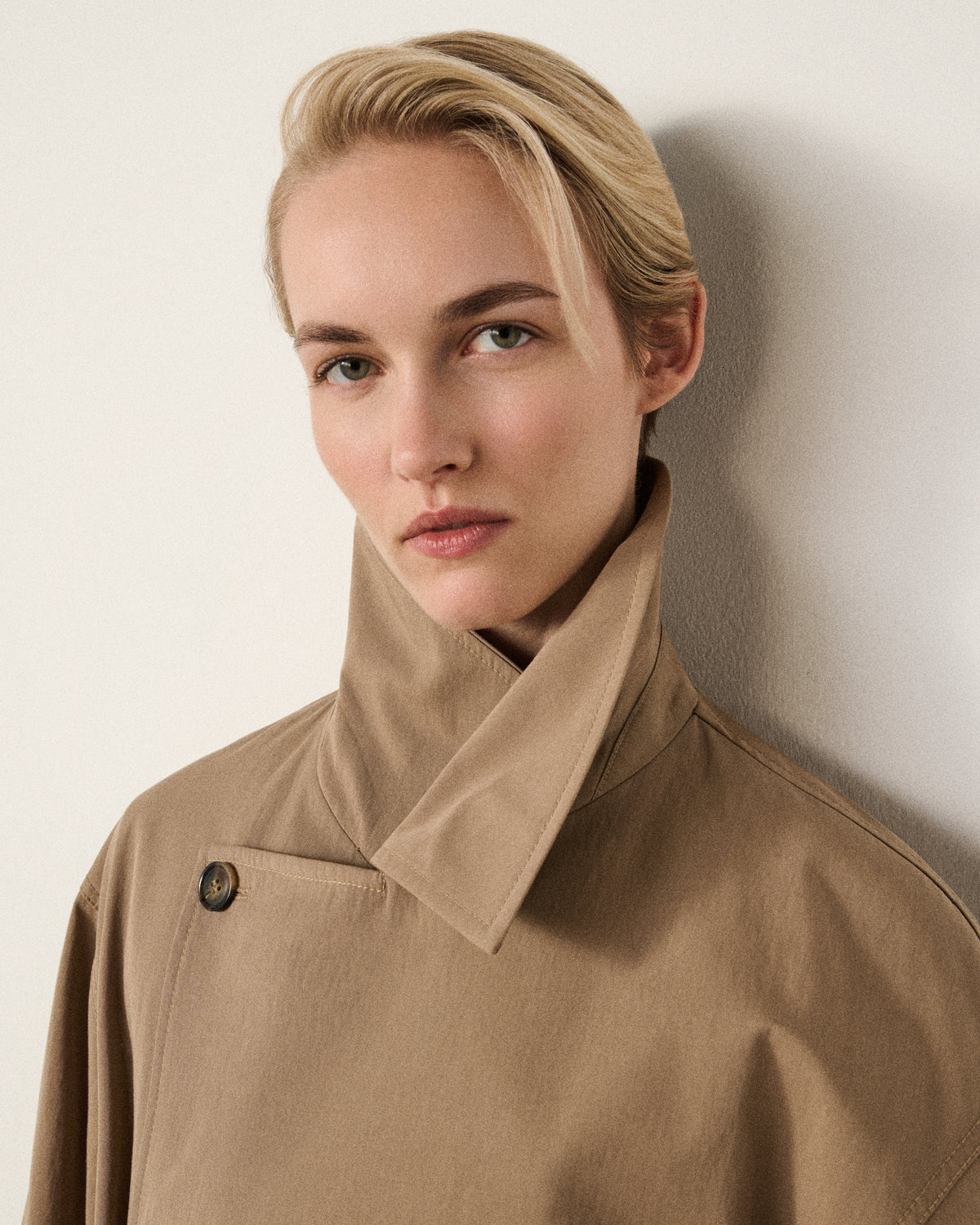 woman wearing the sand trench coat, collar up