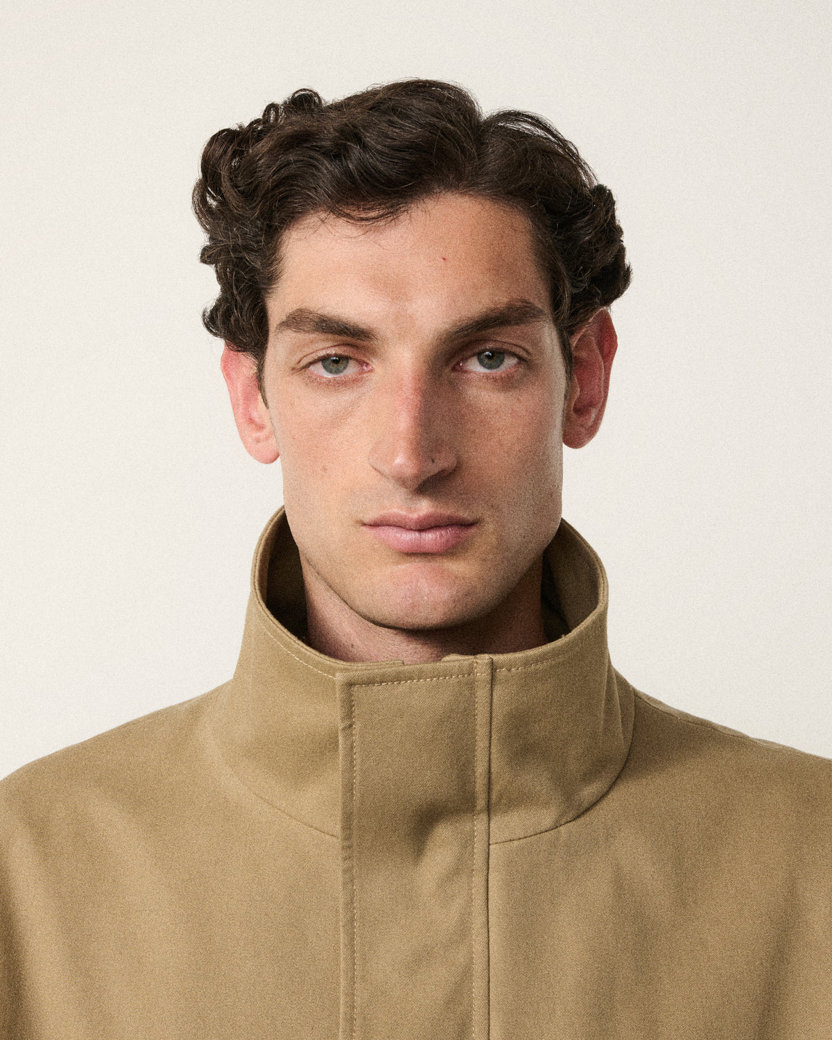 close-up of a man's face in the sand cropped cotton bomber