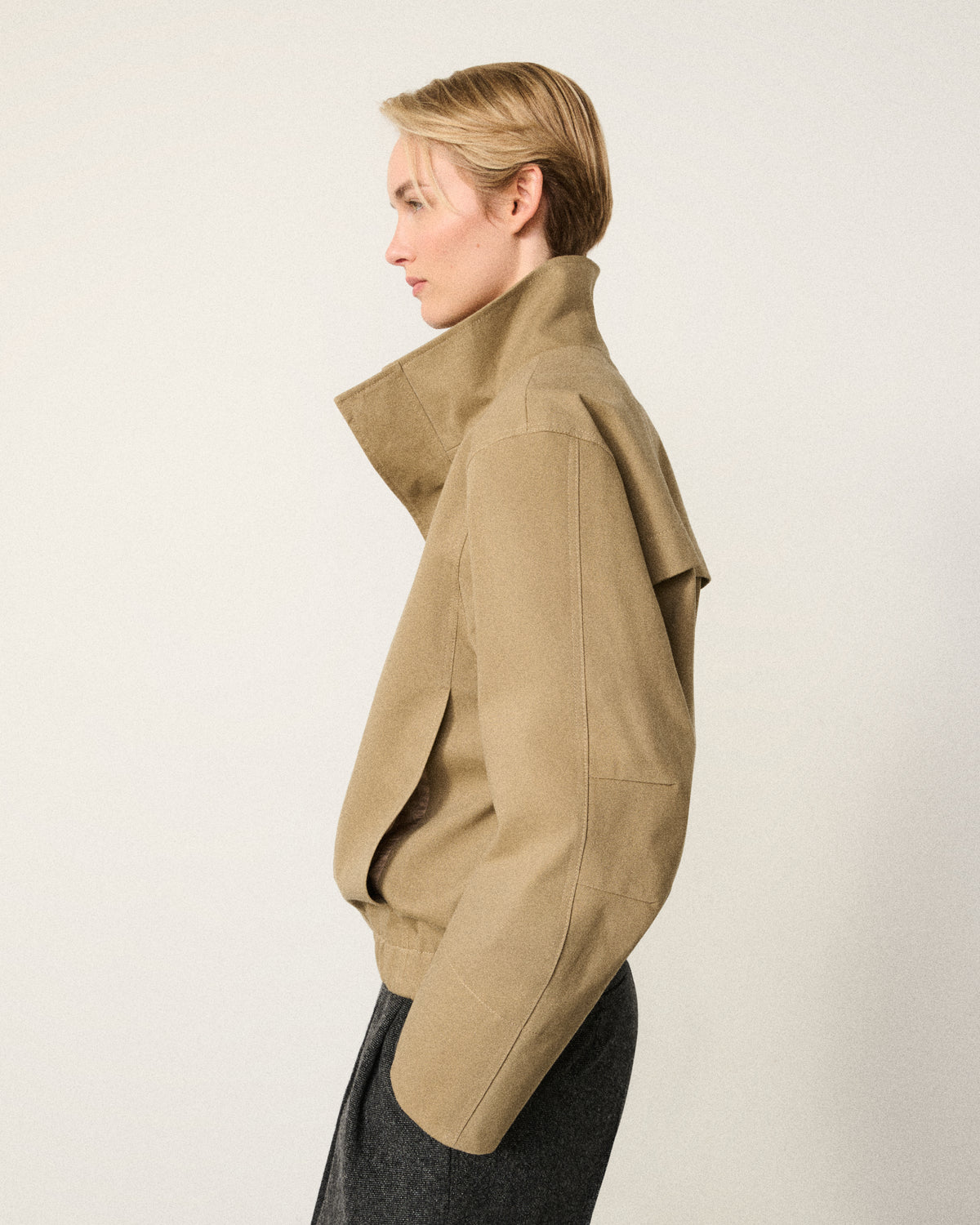 woman in the sand cropped cotton bomber, side profile