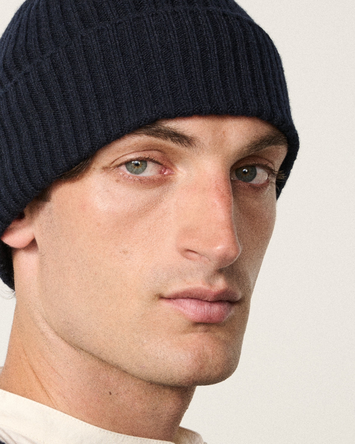 close-up of man's face wearing the navy knitted rib beanie