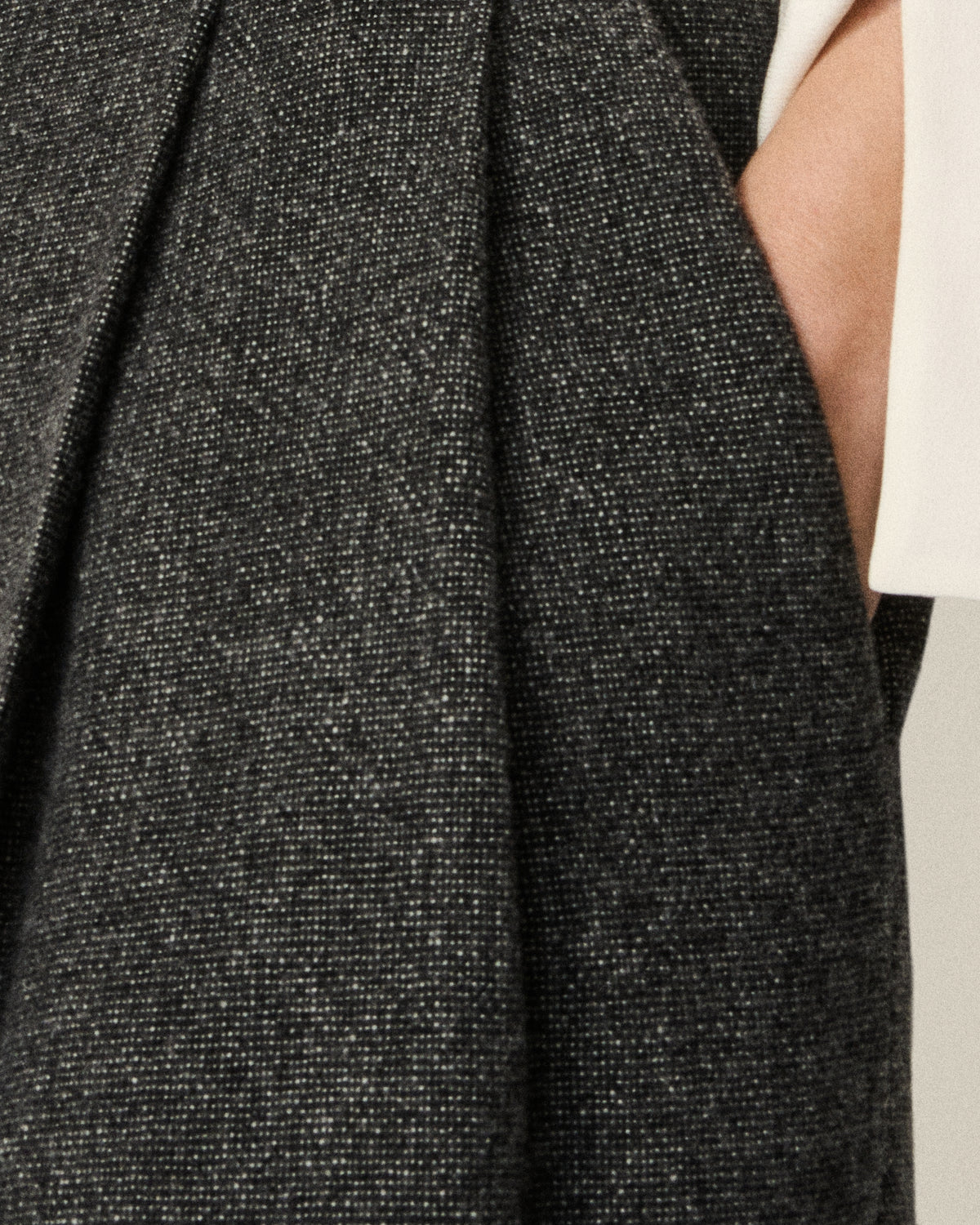 close-up of pleat detail with hand in pocket