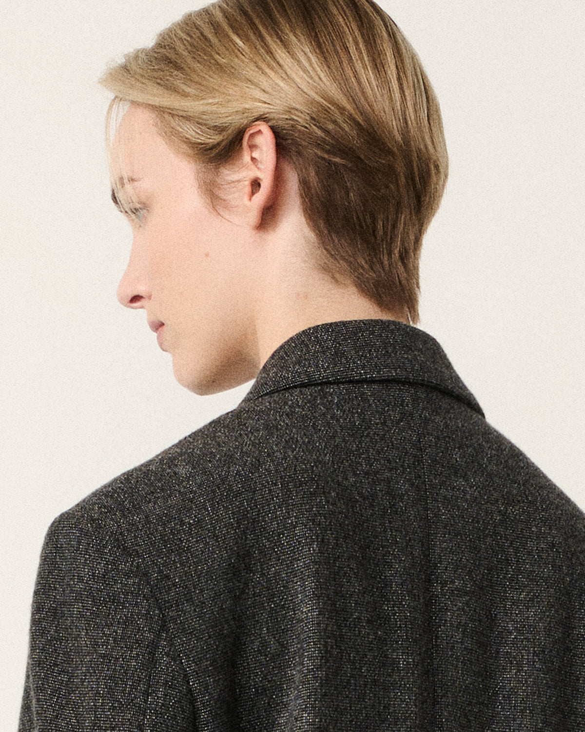 close-up of hair and collar on the dark grey blazer, back