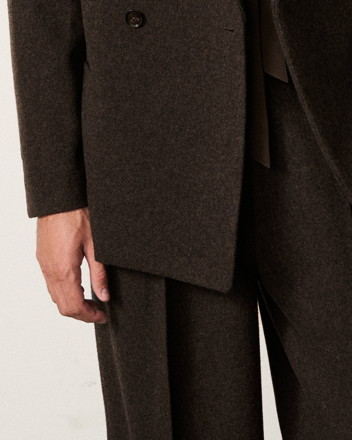 close-up of a man's hand on the chocolate brown blazer