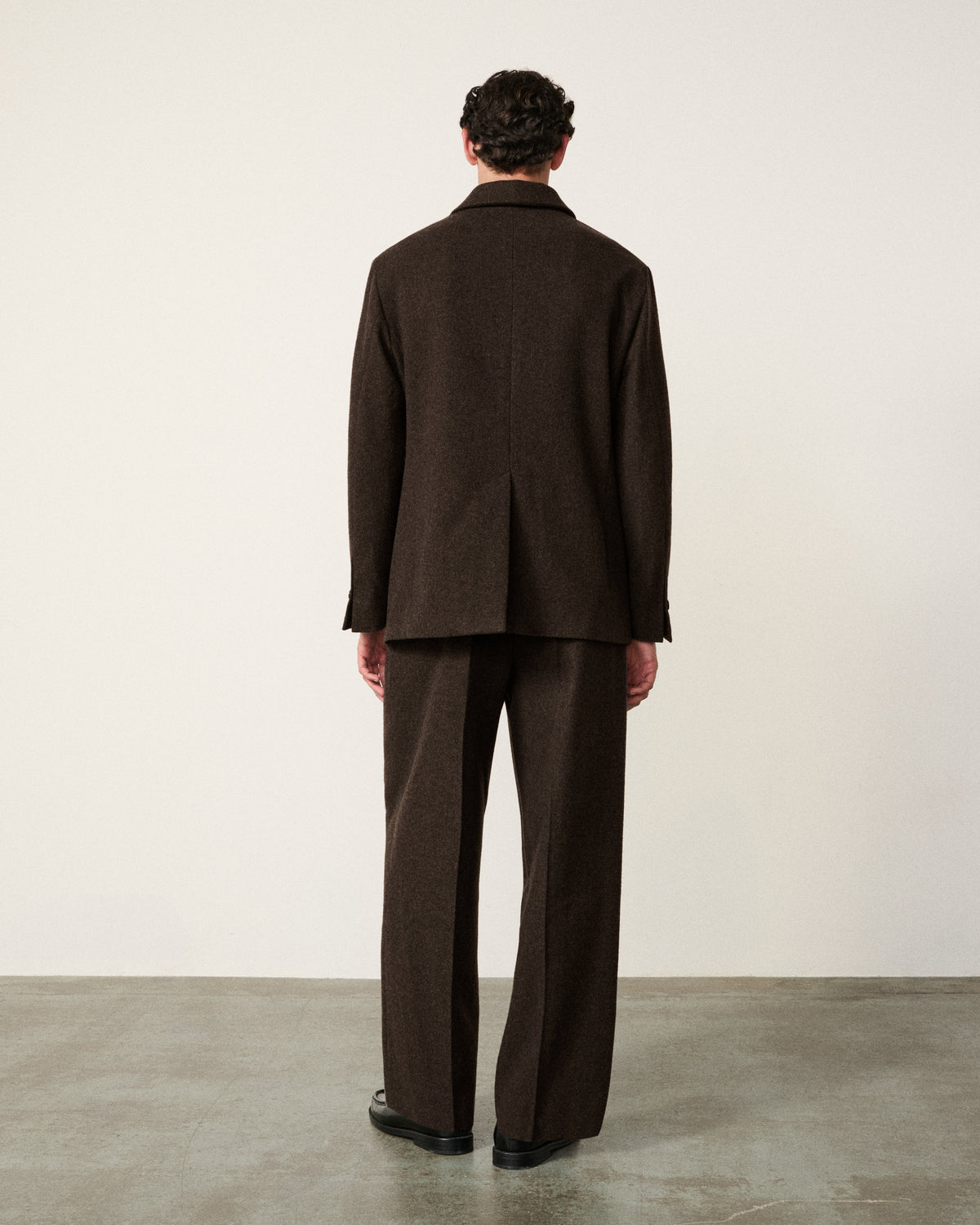 man in the chocolate brown blazer, back view