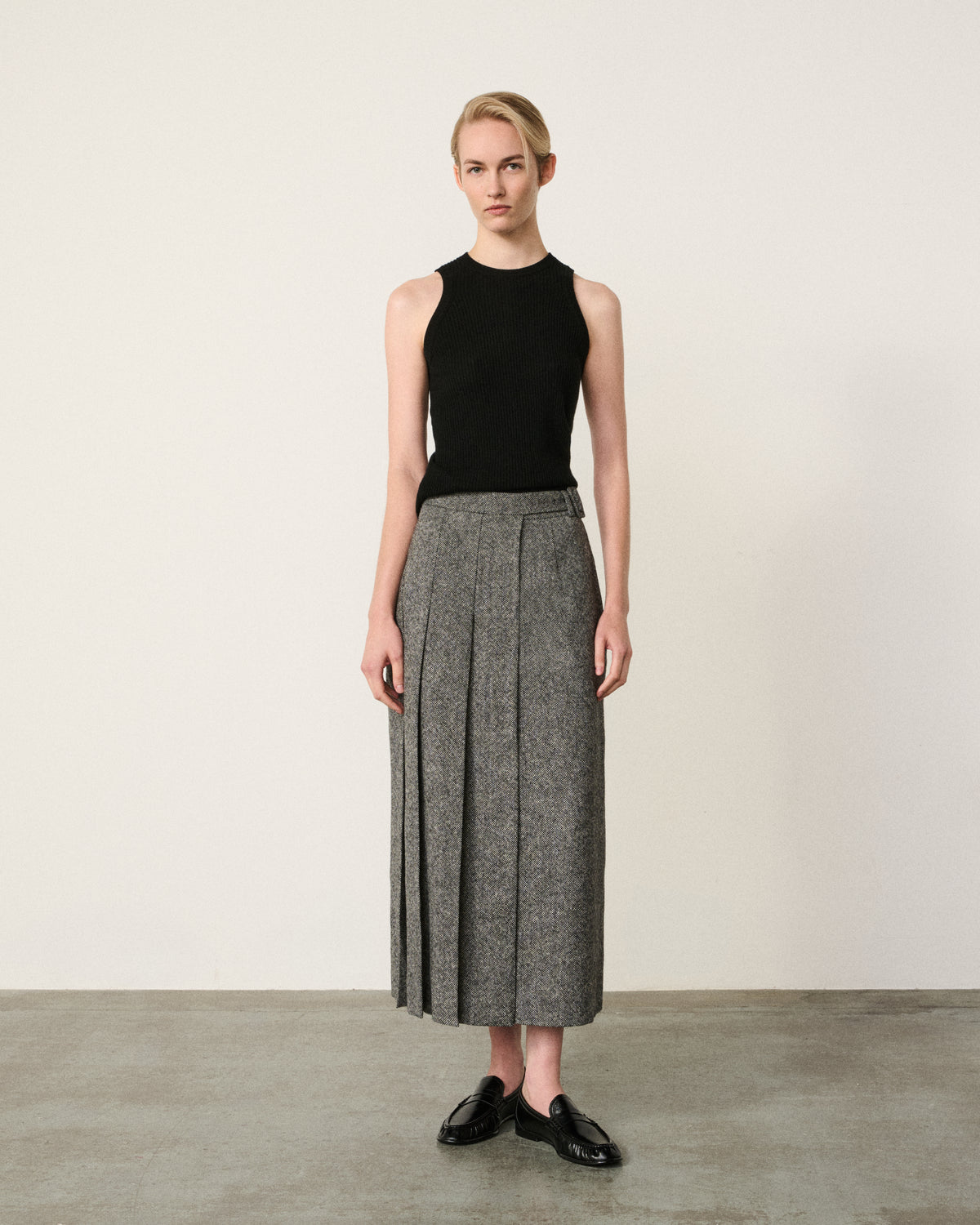 woman in the black and white asymmetric pleated skirt, black top