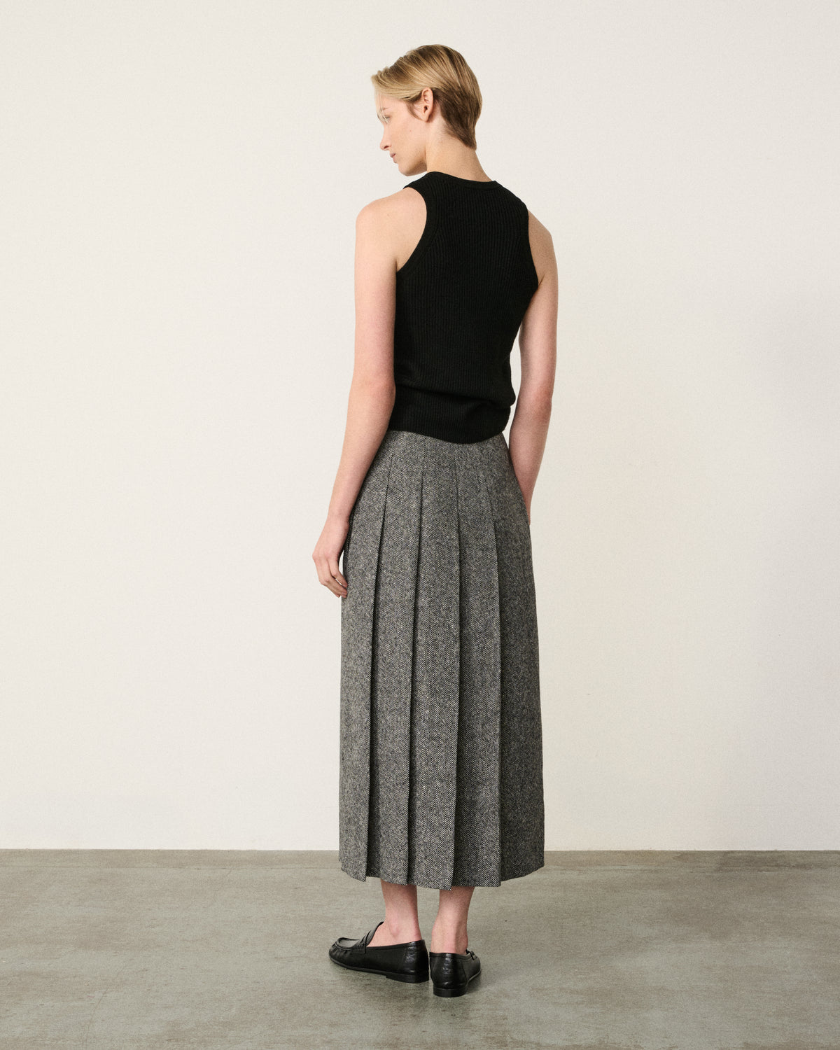 woman in the black and white asymmetric pleated skirt, back view