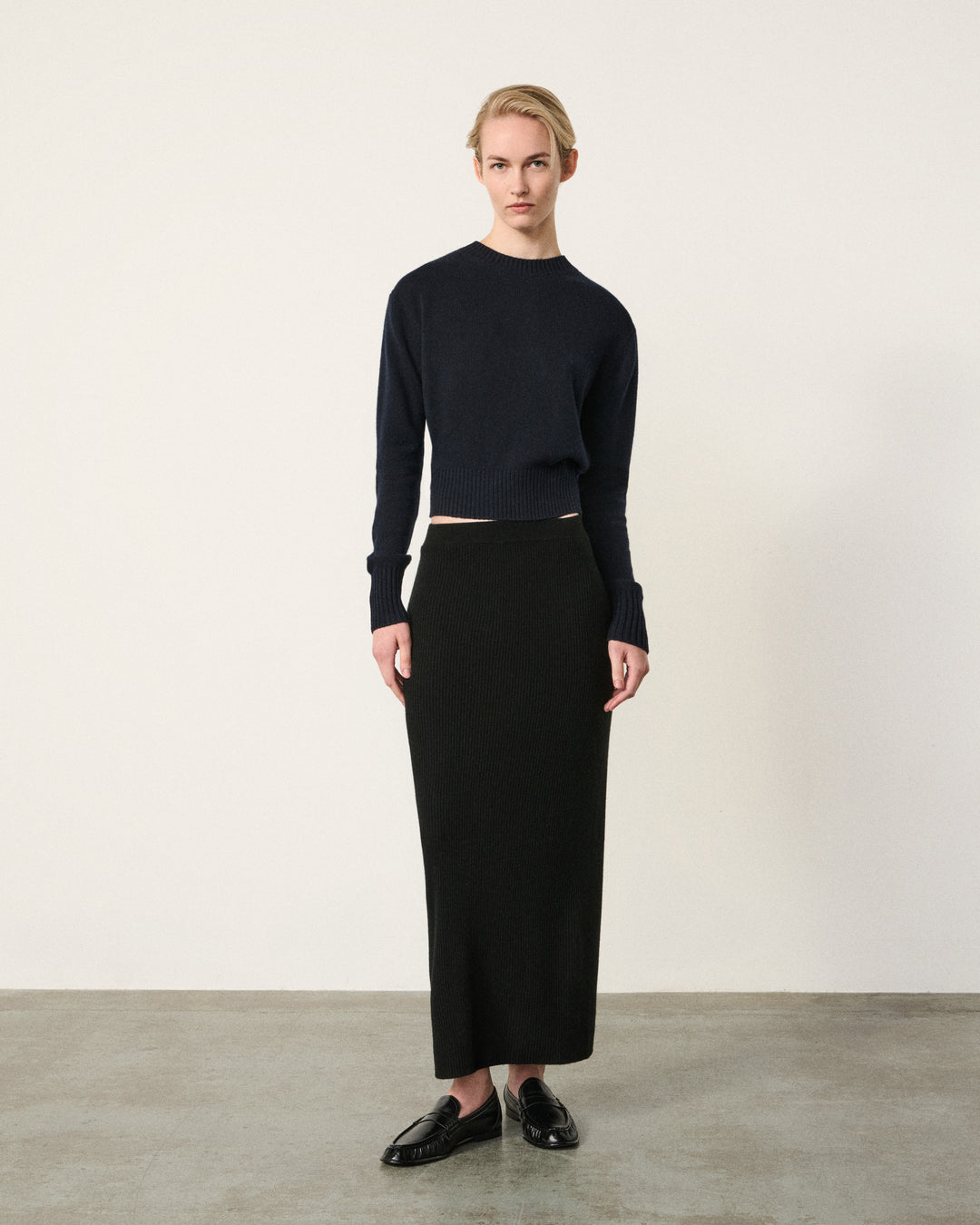 woman in the black ribbed column midi skirt
