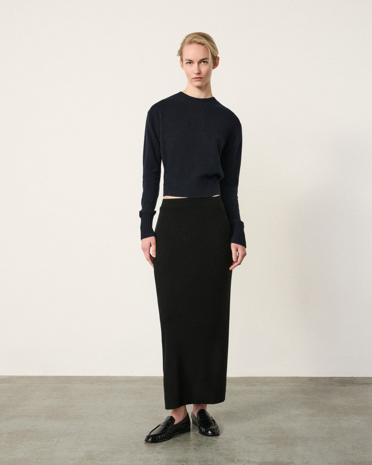 woman in the black ribbed column midi skirt
