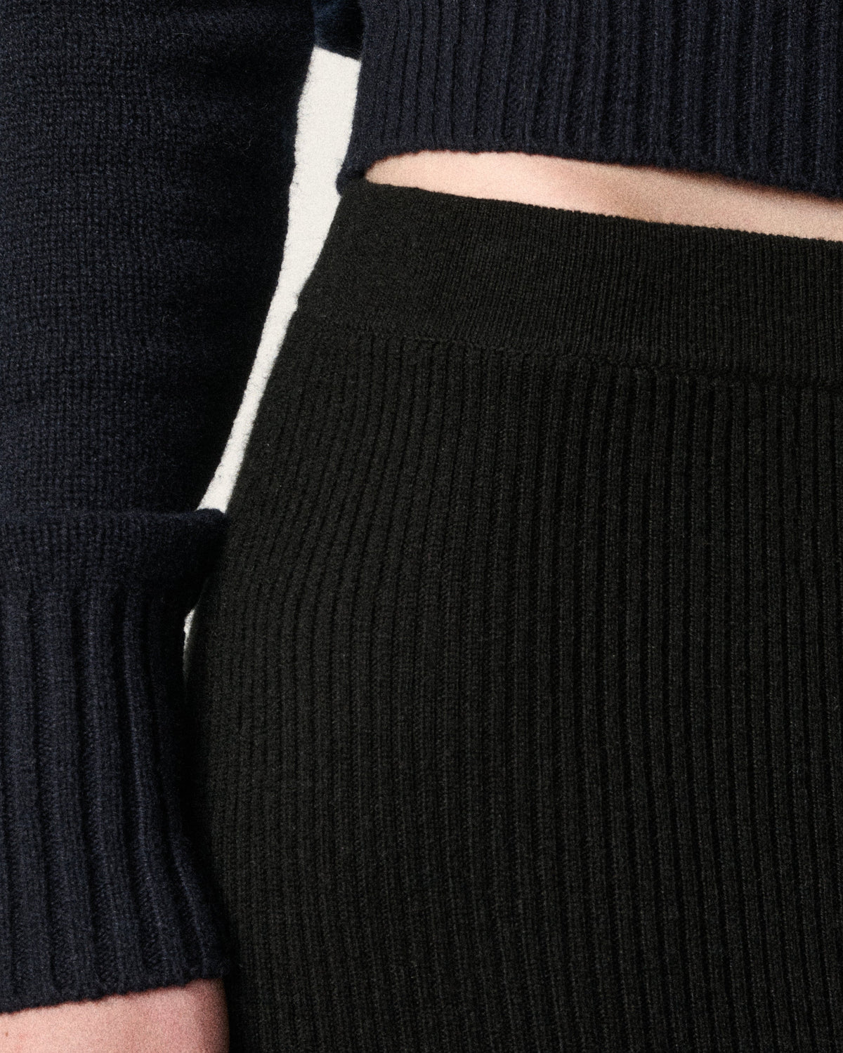 close-up of woman's waist, black ribbed skirt