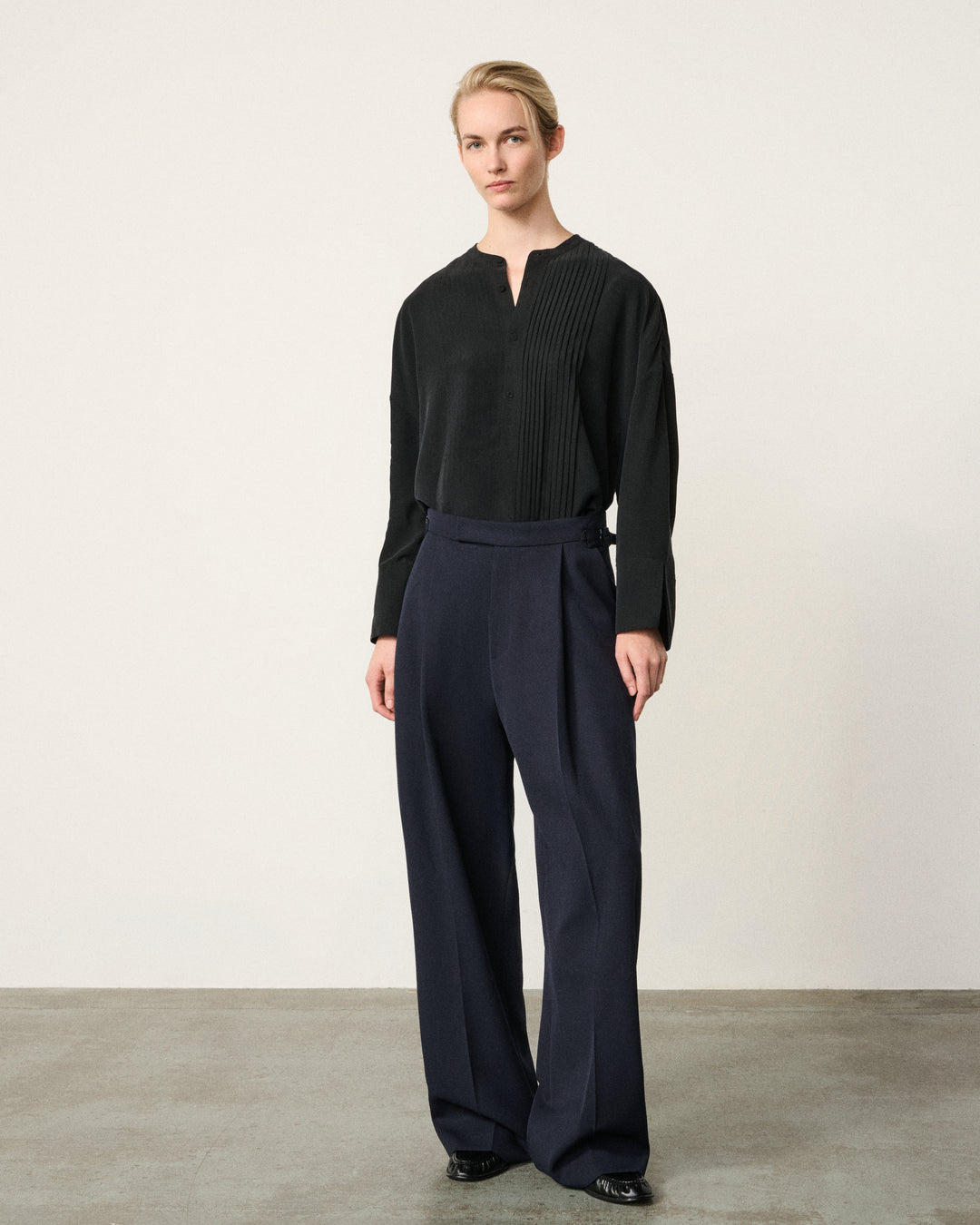 woman in the black tunic tux shirt, navy trousers