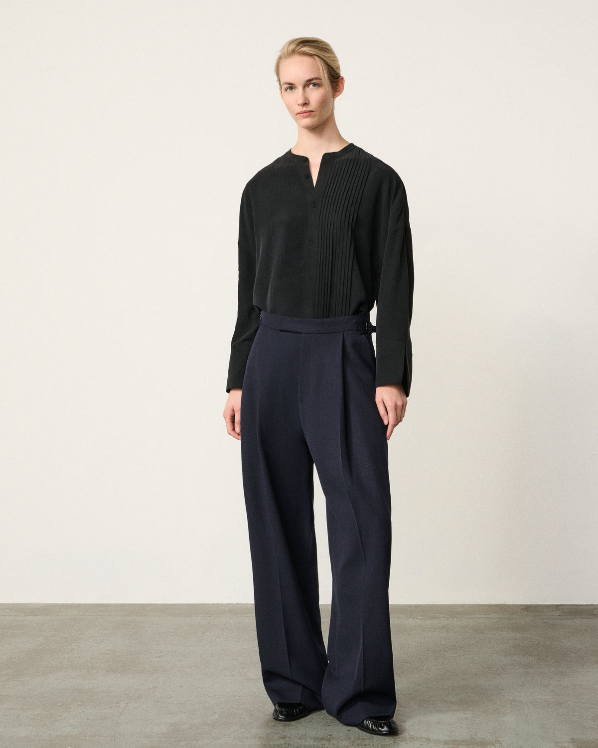 woman in the black tunic tux shirt, navy trousers