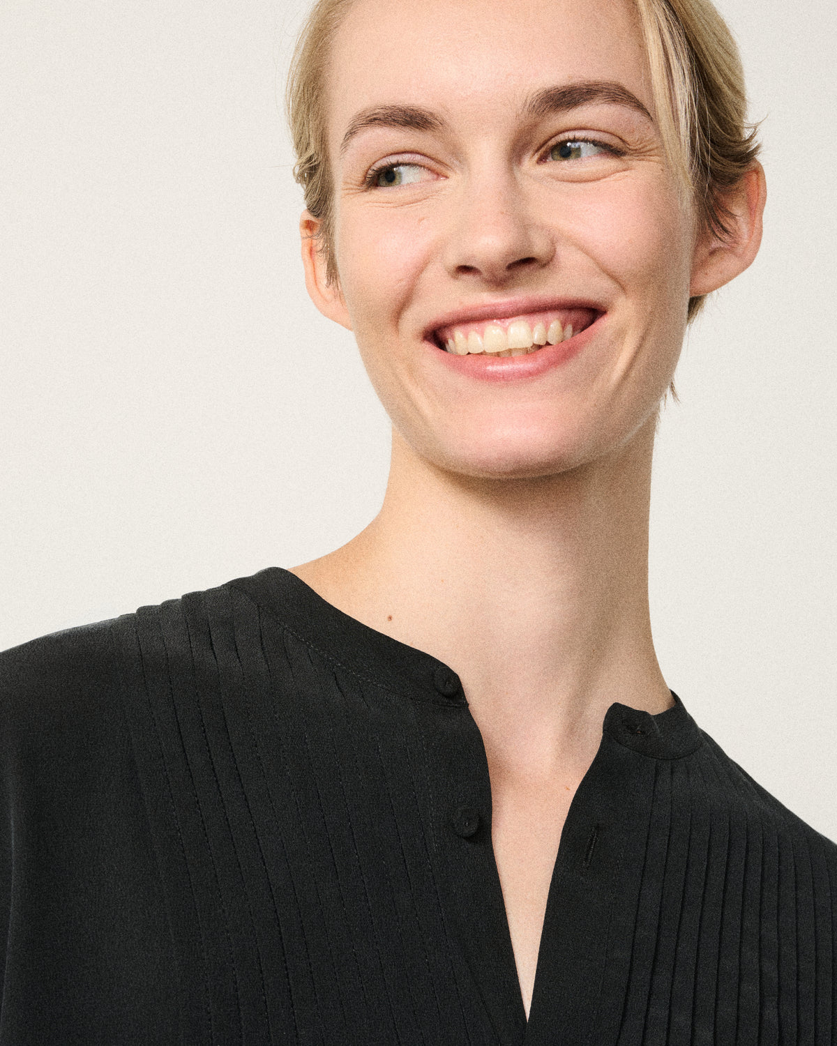 close-up of a woman smiling in the black tux shirt