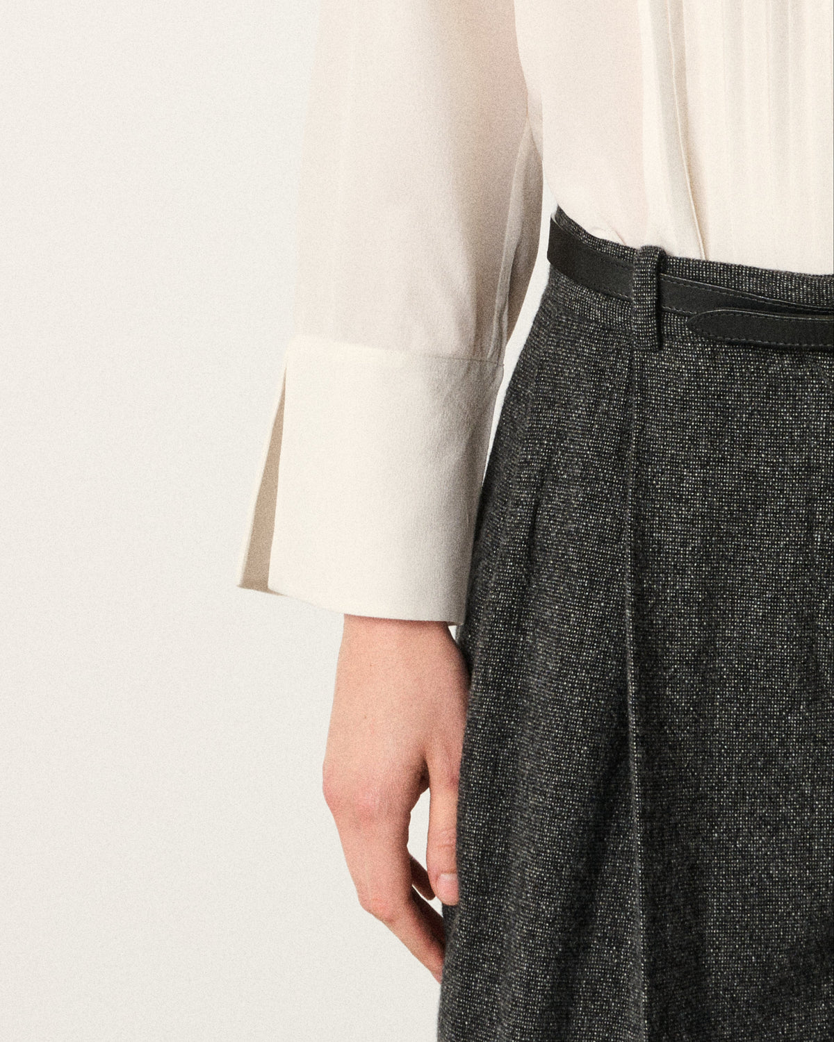 close-up of a woman's hand and the ivory tux shirt cuff