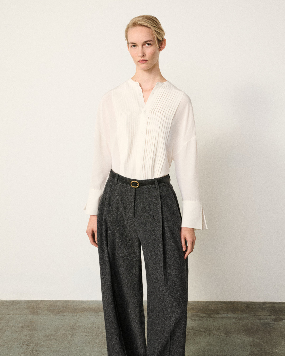 woman in the ivory tunic tux shirt, grey trousers