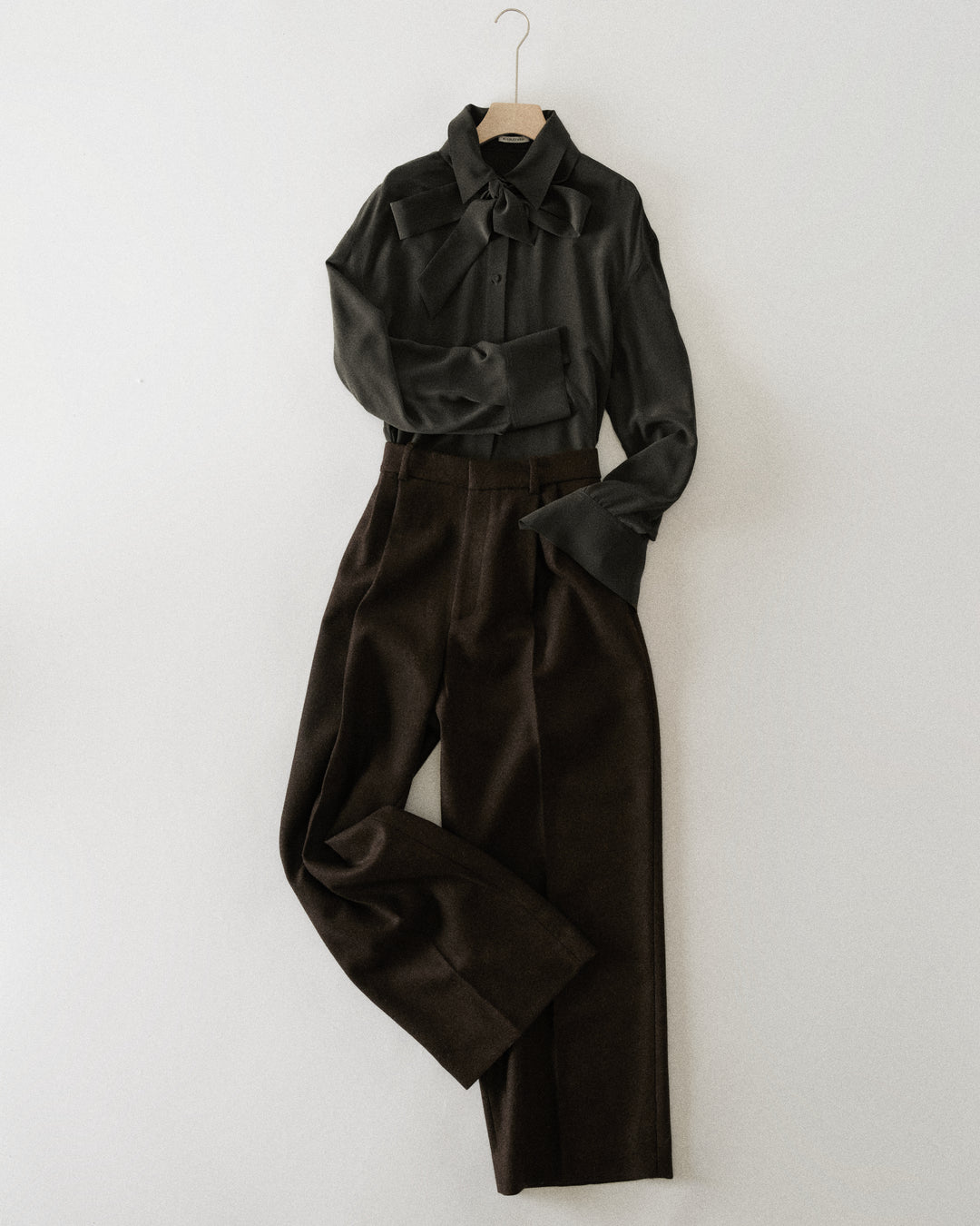charcoal silk shirt and brown trousers hanging together