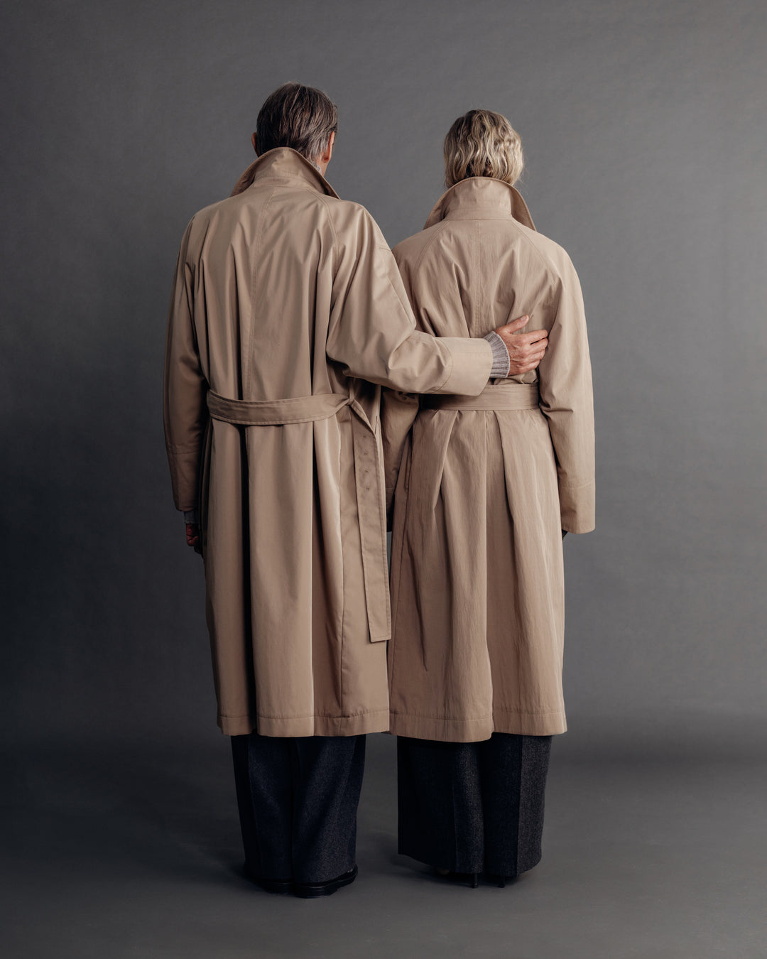 man and woman in the sand trench coat, back view