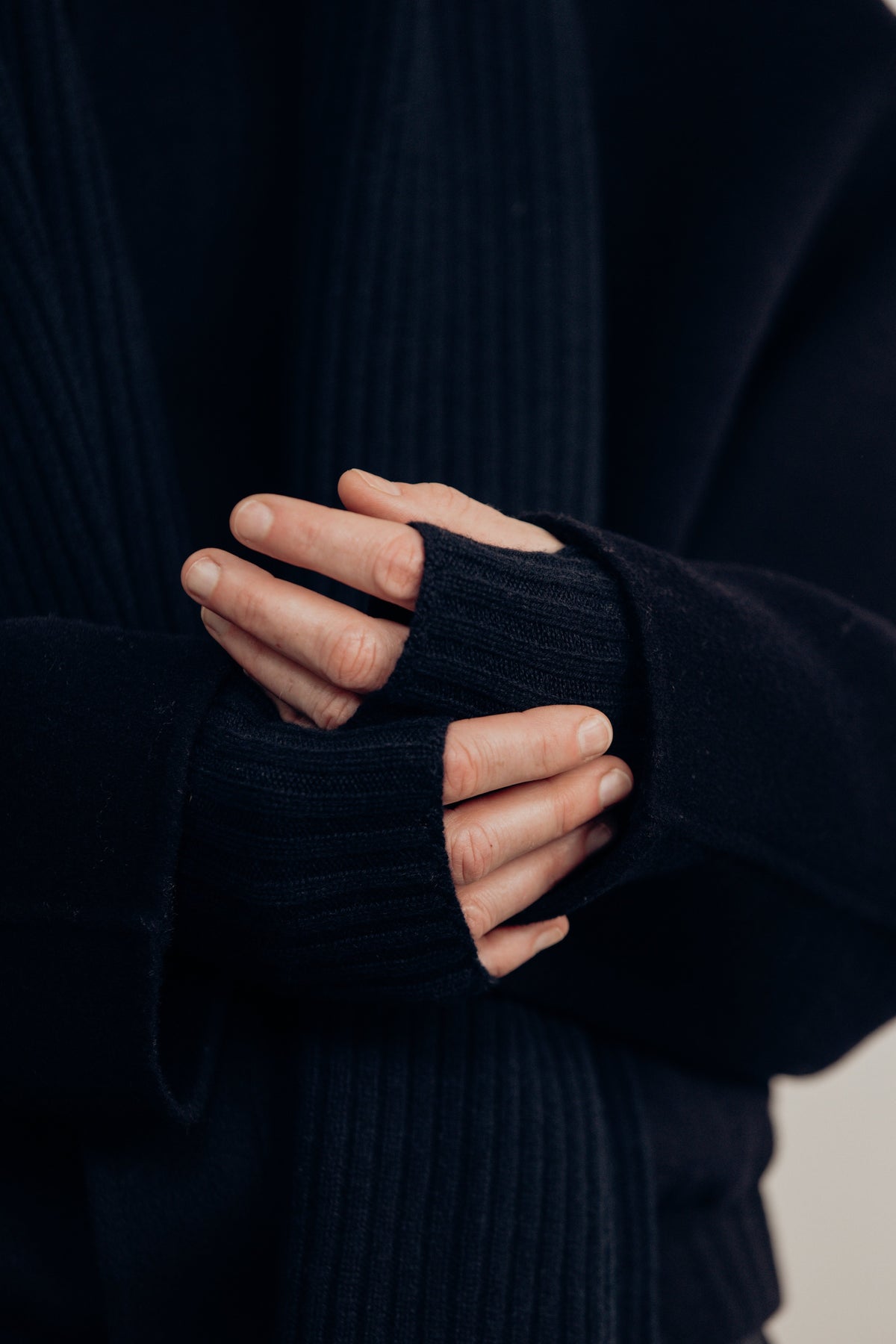close-up of hands wearing the navy ribbed fingerless gloves