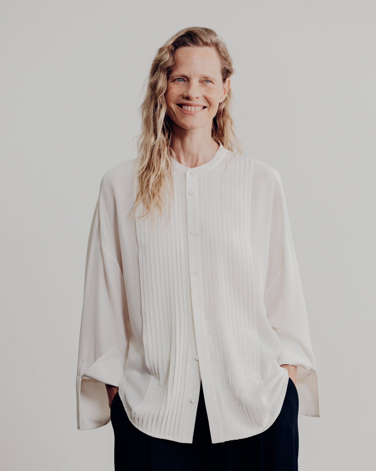 woman smiling in the ivory tunic tux shirt