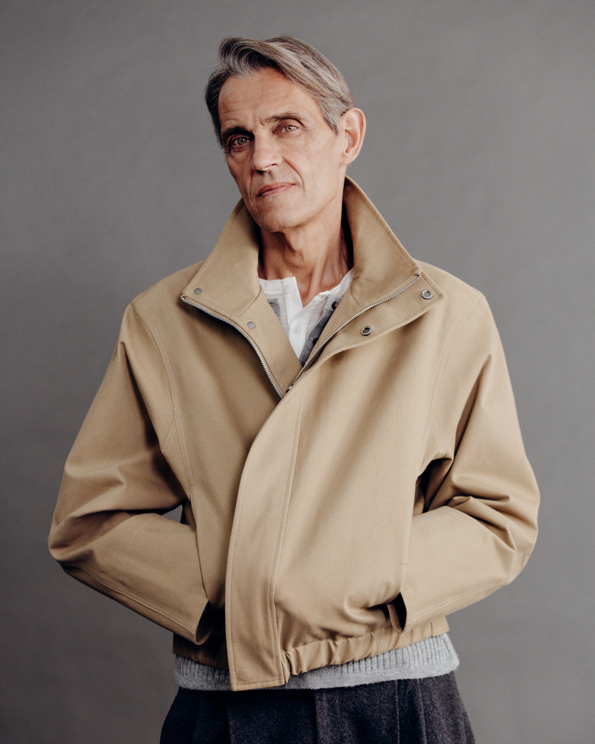 man in the sand cropped cotton bomber, front view